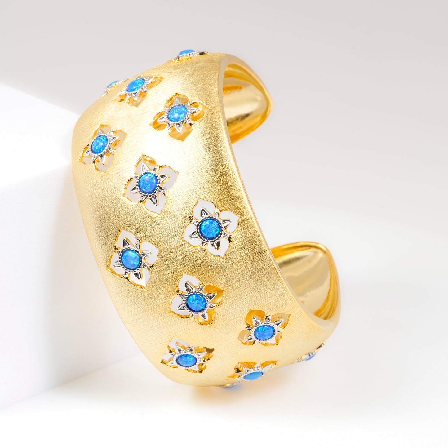 Wide Gold Cuff Bracelet with Intricate Blue Stone Floral Motifs and Satin Finish | Regal Statement Jewelry for Weddings, Festivals, and Special Occasions