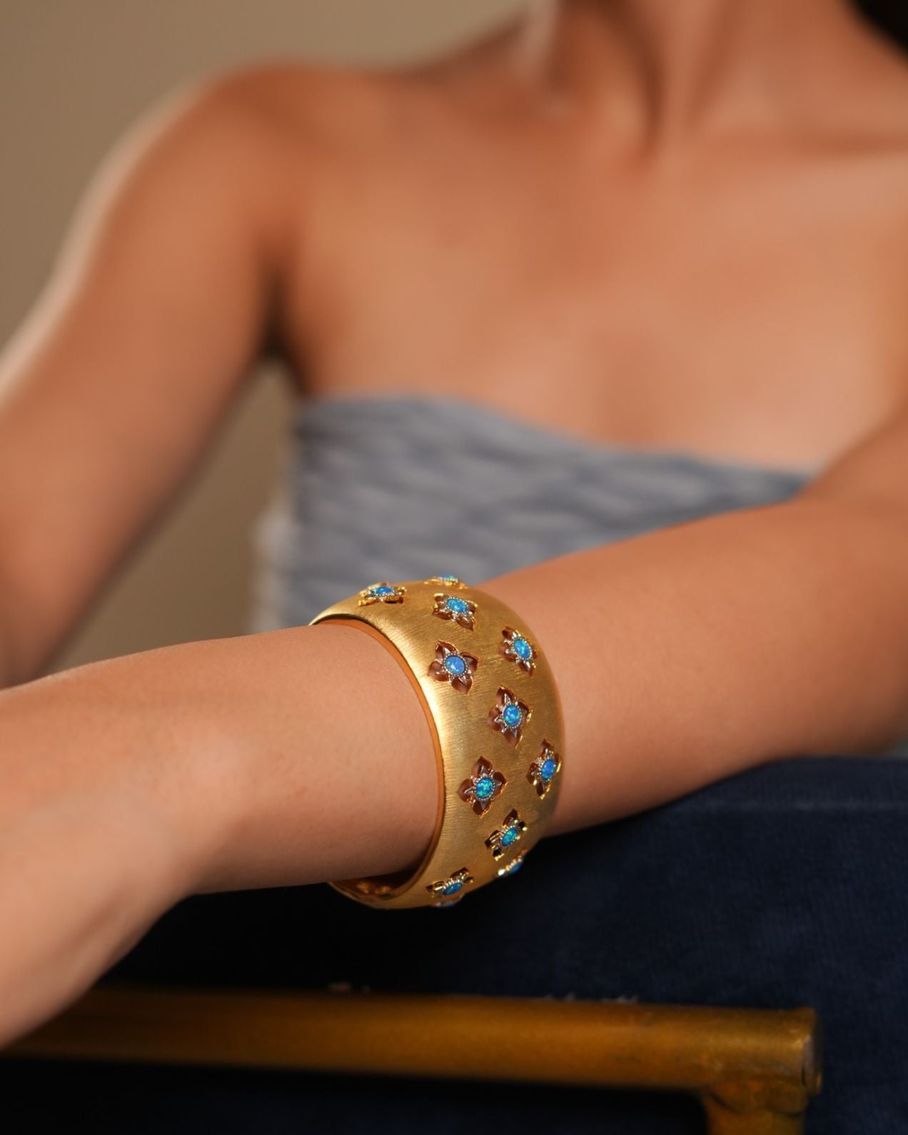 Wide Gold Cuff Bracelet with Intricate Blue Stone Floral Motifs and Satin Finish | Regal Statement Jewelry for Weddings, Festivals, and Special Occasions