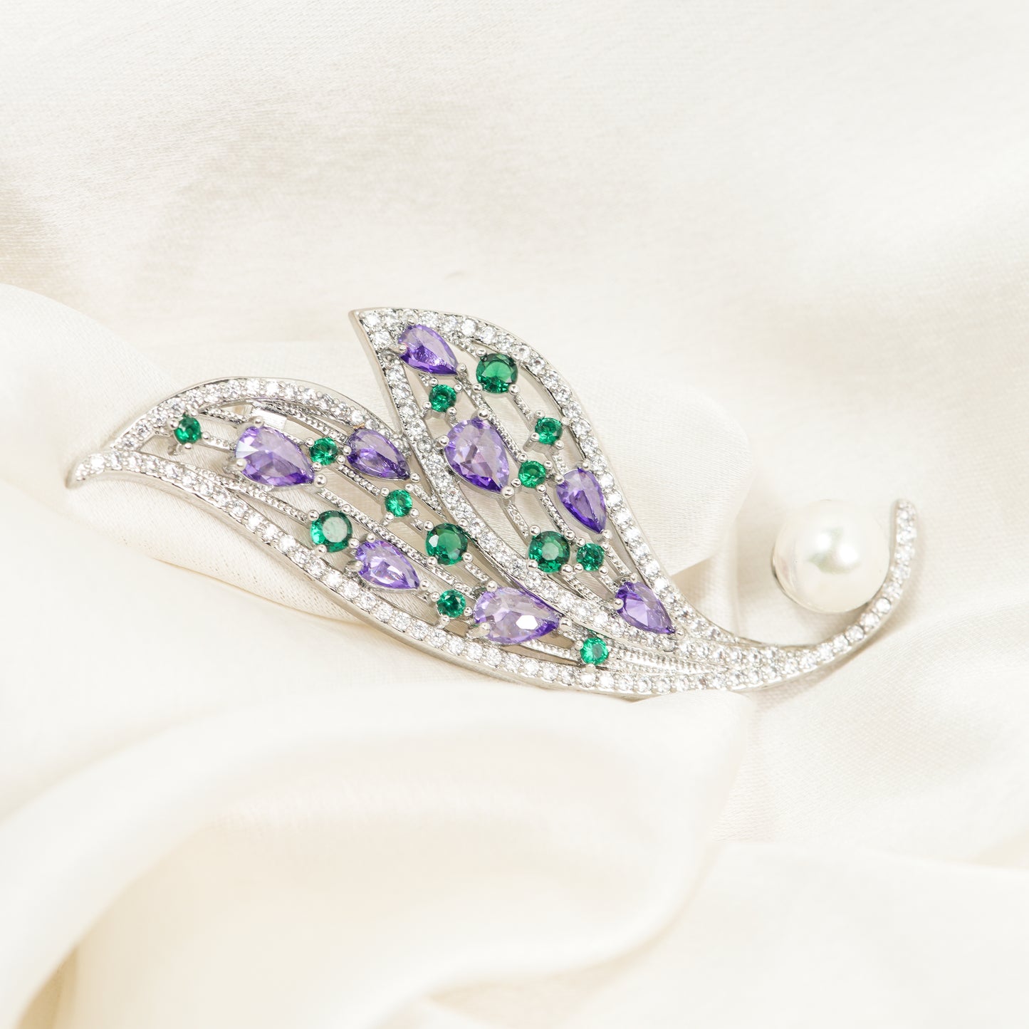 Amethyst and Emerald Feather Brooch | Silver Tone Wing Inspired Brooch with Purple Teardrop and Green Round CZ Stones, Full Pave Finish and Pearl Accent | Elegant Festive and Bridal Statement Pin